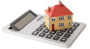 A small toy house rests on a calculator